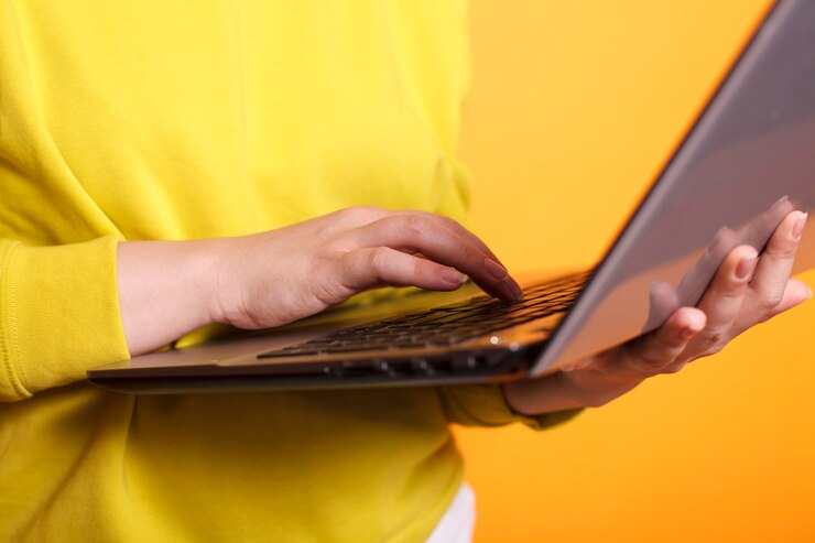 Foto gratuito la mano de la mujer agarrando una computadora portátil moderna.