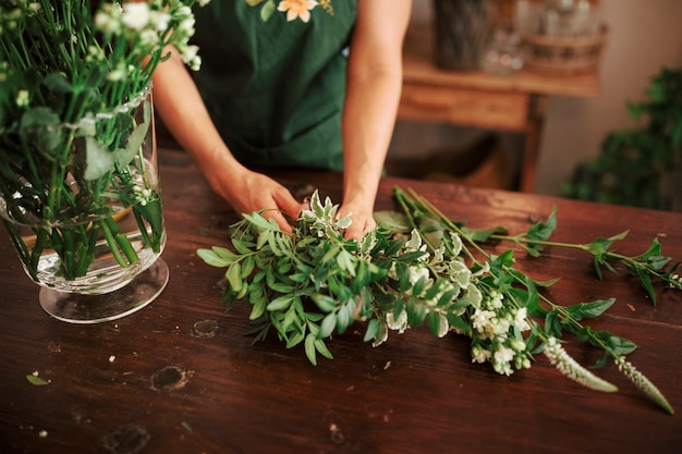 Mano de mujer arreglando plantas en florero