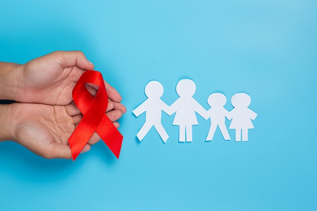 Mano de mujer con cinta roja Concepto de concienciación sobre el VIH Día Mundial del SIDA y Día Mundial de la Salud Sexual.