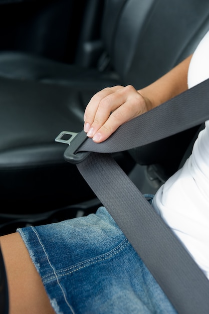 Foto gratuita mano de mujer con cinturón de seguridad en el coche - al aire libre