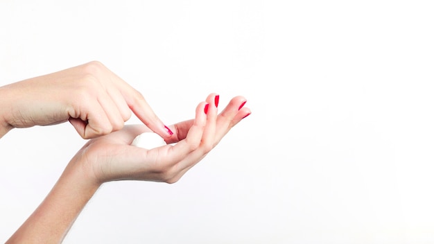 Mano de mujer con crema hidratante aislada sobre fondo blanco