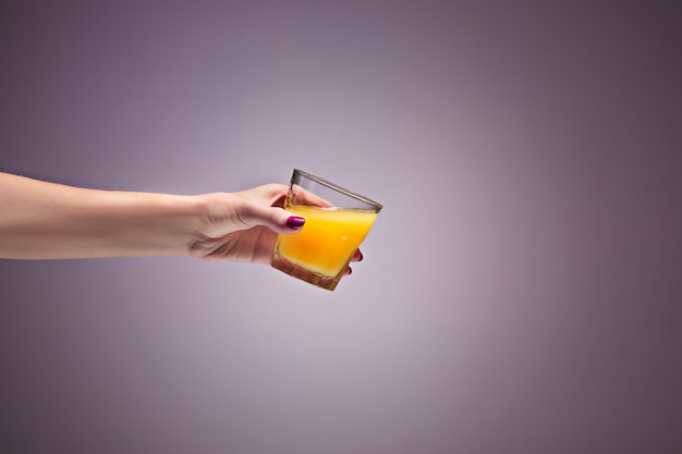 Foto gratuita mano de mujer con jugo de naranja