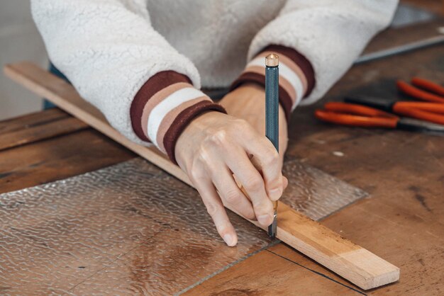 Mano de mujer maestra vidriera trabajando en un taller.