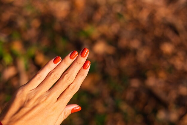 Mano de mujer con manicura naranja