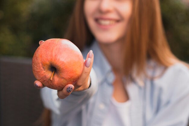 Mano de mujer ofreciendo una deliciosa manzana