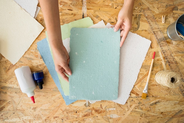 Mano de mujer con papel hecho a mano sobre el escritorio de madera