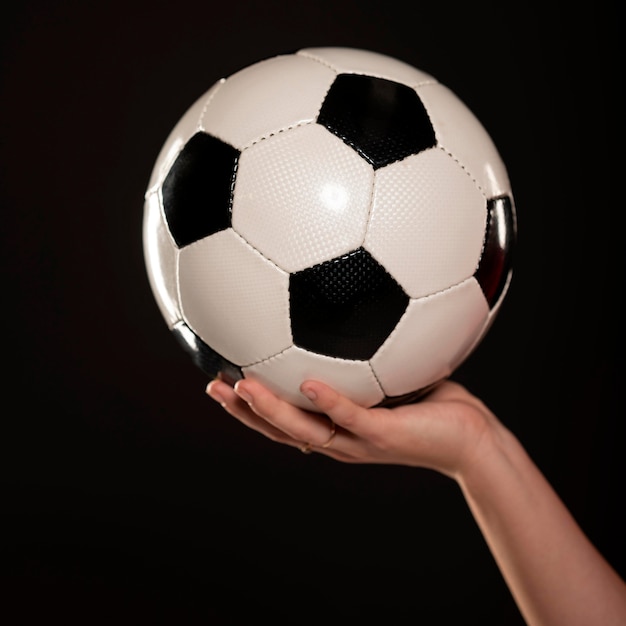 Mano de mujer con pelota de fútbol de cerca
