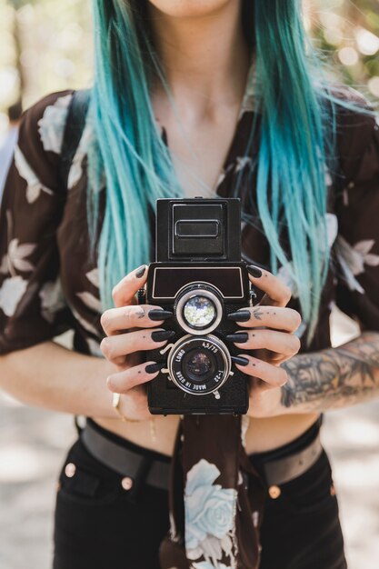 La mano de la mujer que sostiene la lente de la cámara gemela de la foto vieja reflex