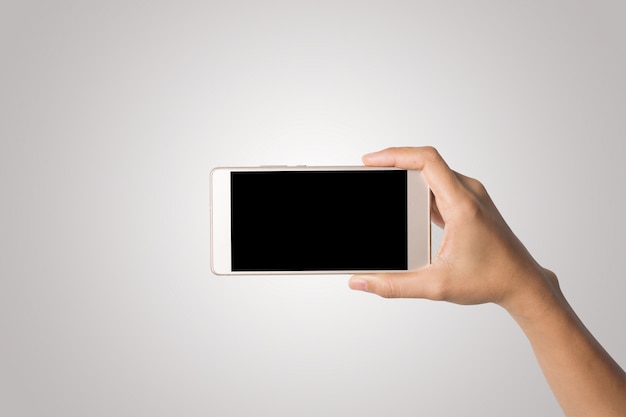 Foto gratuita mano de la mujer que sostiene la pantalla en blanco del teléfono elegante. copie el espacio. mano que sostiene el smartphone aislado en el fondo blanco.