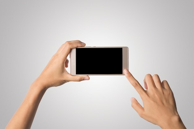 Mano de la mujer que sostiene la pantalla en blanco del teléfono elegante. Copie el espacio. Mano que sostiene el smartphone aislado en el fondo blanco.