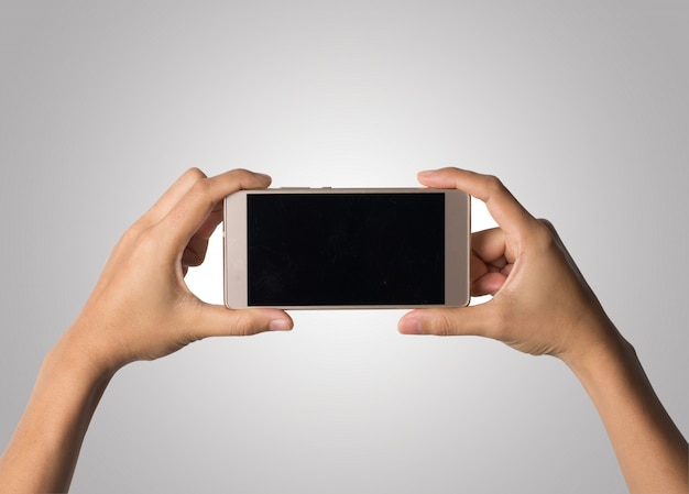 Mano de la mujer que sostiene la pantalla en blanco del teléfono elegante. Copie el espacio. Mano que sostiene el smartphone aislado en el fondo blanco.