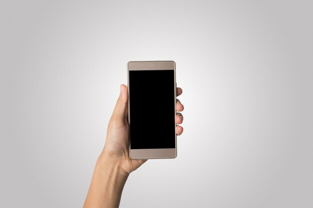 Mano de la mujer que sostiene la pantalla en blanco del teléfono elegante. Copie el espacio. Mano que sostiene el smartphone aislado en el fondo blanco.