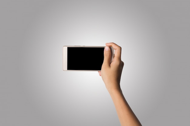 Mano de la mujer que sostiene la pantalla en blanco del teléfono elegante. Copie el espacio. Mano que sostiene el smartphone aislado en el fondo blanco.