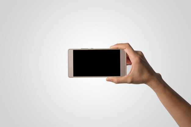 Mano de la mujer que sostiene la pantalla en blanco del teléfono elegante. Copie el espacio. Mano que sostiene el smartphone aislado en el fondo blanco.