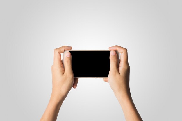 Mano de la mujer que sostiene la pantalla en blanco del teléfono elegante. Copie el espacio. Mano que sostiene el smartphone aislado en el fondo blanco.