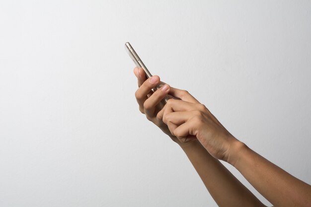 Mano de la mujer que sostiene la pantalla en blanco del teléfono elegante. Copie el espacio. Mano que sostiene el smartphone aislado en el fondo blanco.