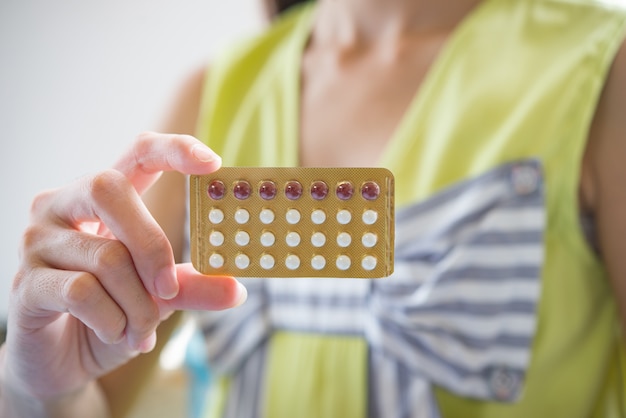 Mano de mujer sosteniendo un panel anticonceptivo previene el embarazo.