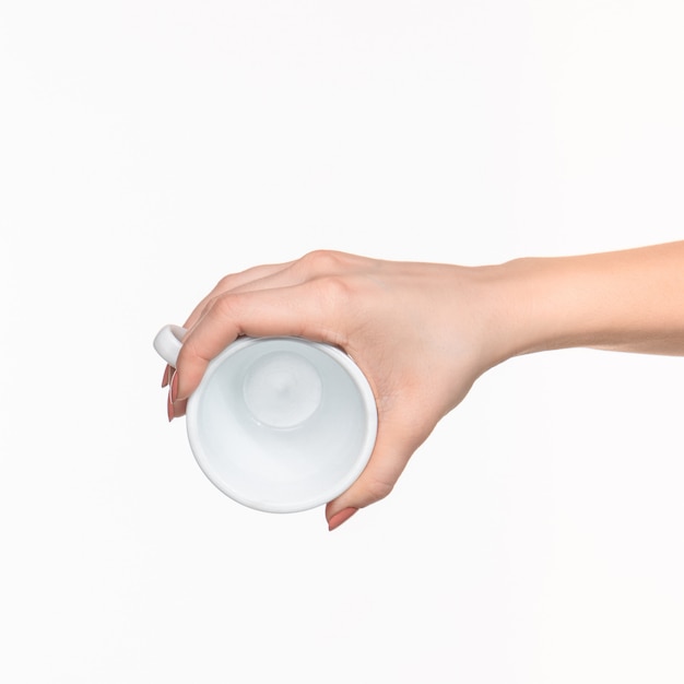 Mano de mujer con taza blanca perfecta sobre blanco