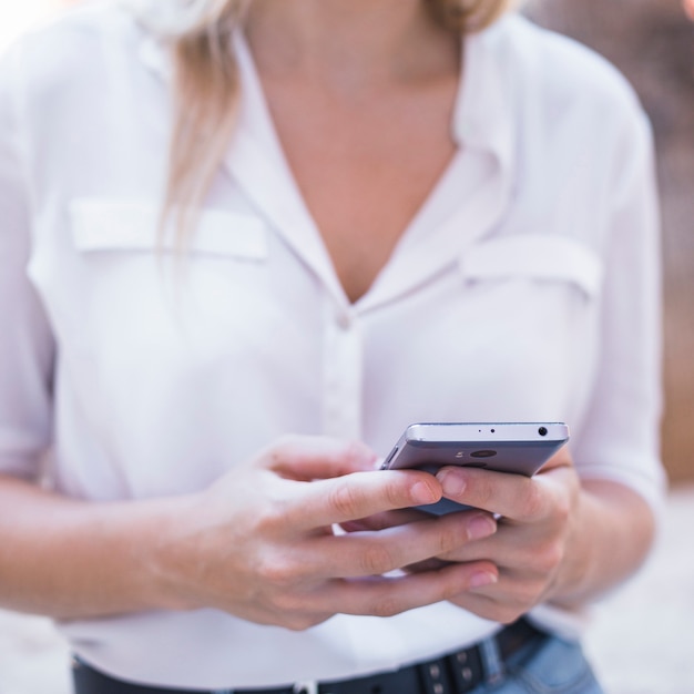 Mano de mujer usando teléfono móvil