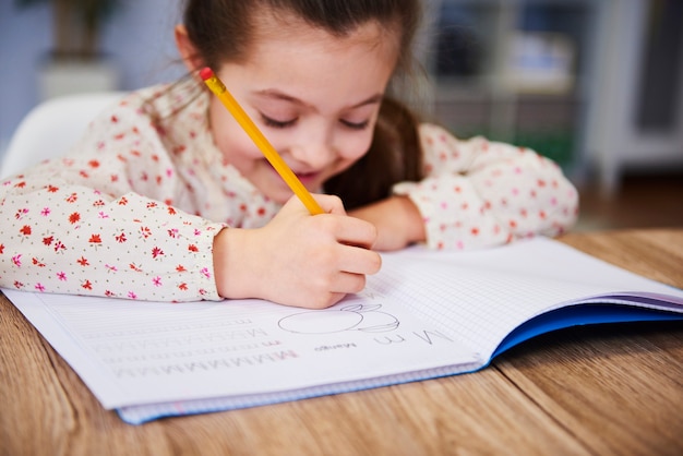 Mano de niña escribiendo en su cuaderno