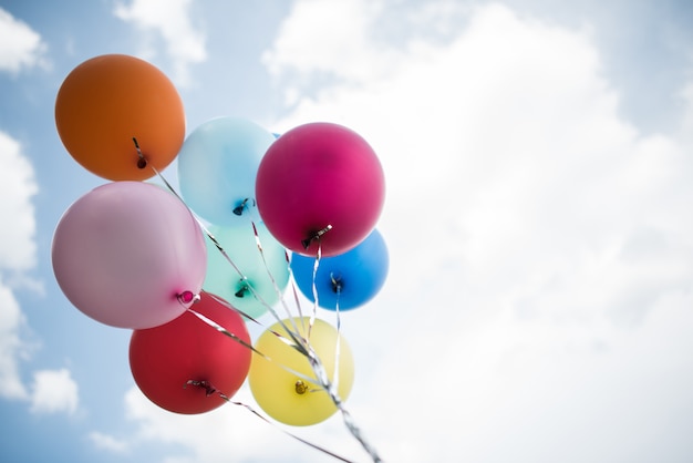 Mano de niña sosteniendo globos de colores