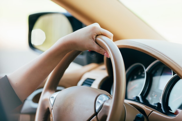 Mano de niña en el timón del coche