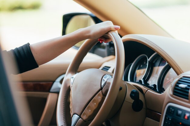 Mano de niña en el timón del coche