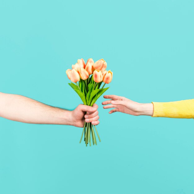 Mano ofreciendo ramo de flores