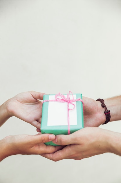 Mano de la pareja con caja de regalo verde