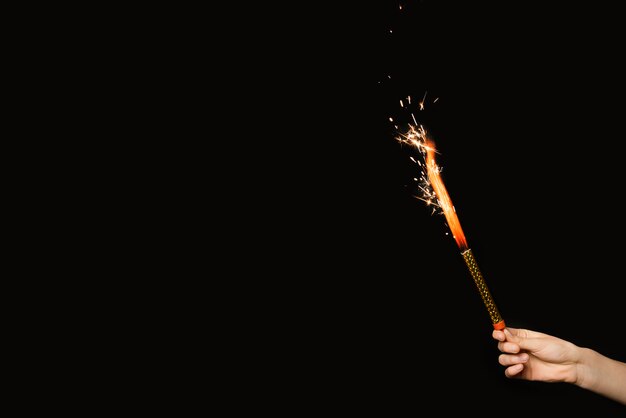 Mano de la persona con fuegos artificiales en llamas