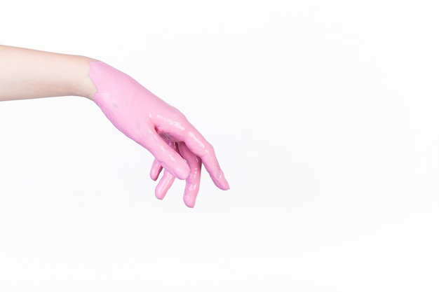Mano de la persona pintada con color rosa sobre fondo blanco
