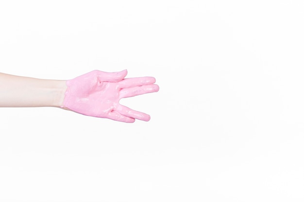 La mano de una persona con pintura rosa haciendo saludo vulcan