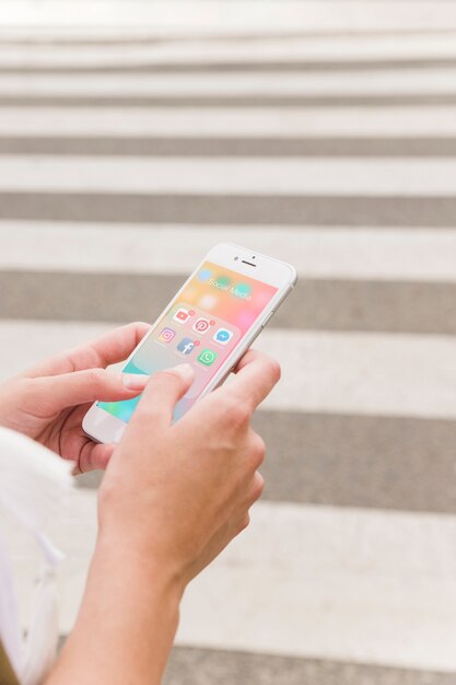 Mano de la persona que sostiene el teléfono móvil con notificaciones de redes sociales en la pantalla