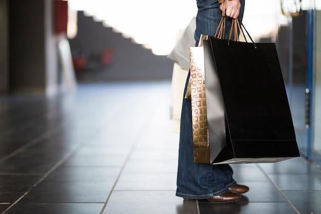 Mano y piernas con bolsas de compras