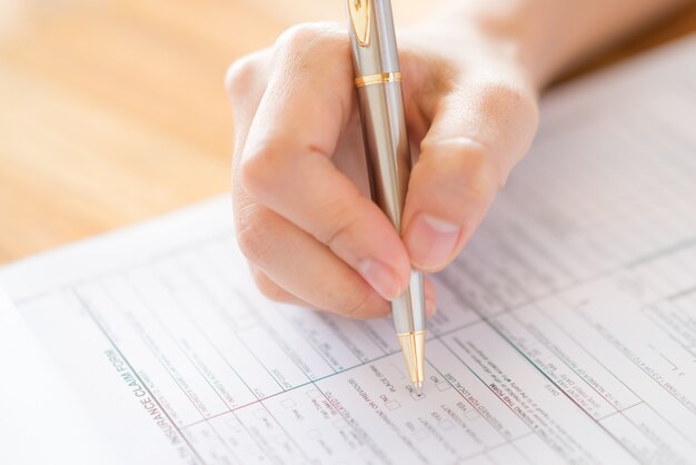 Mano con la pluma sobre el formulario de solicitud