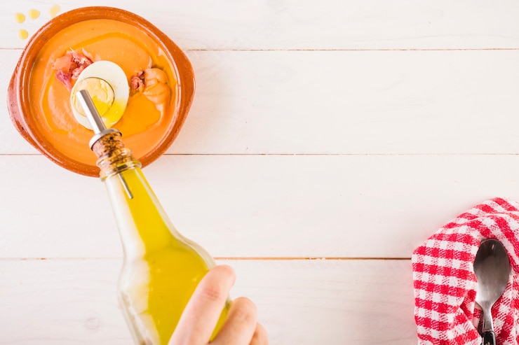 Foto gratuito mano poner aceite en un plato de sopa