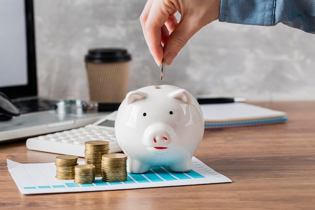 Foto gratuita mano poniendo monedas en la hucha y tabla de crecimiento