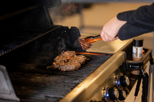 Mano de primer plano cocinar carne deliciosa