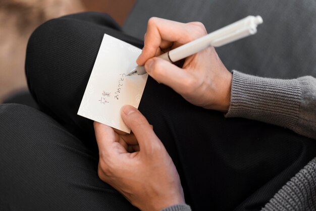 Mano de primer plano escribiendo una nota