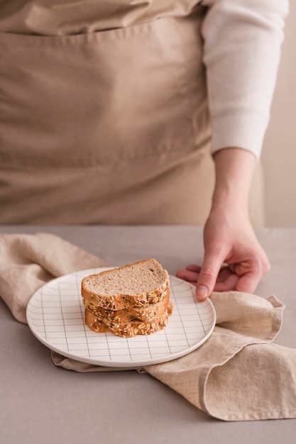 Mano de primer plano con pan en plato