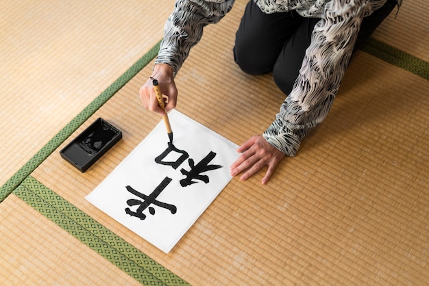 Mano de primer plano pintura letra japonesa