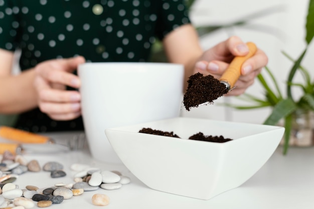 Mano de primer plano que sostiene la paleta de jardinería con tierra