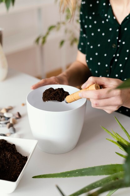 Mano de primer plano que sostiene la paleta de jardinería