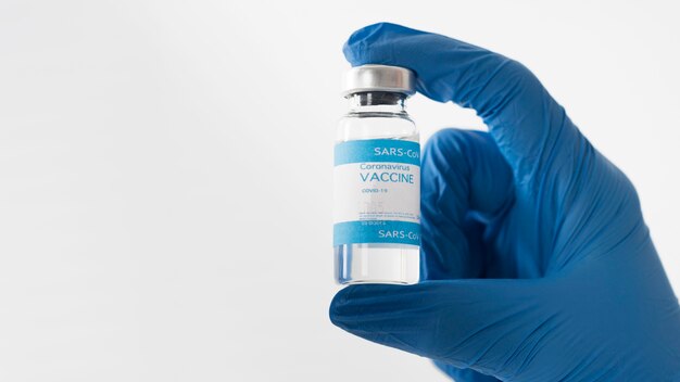 Mano de primer plano que sostiene la vacuna covid