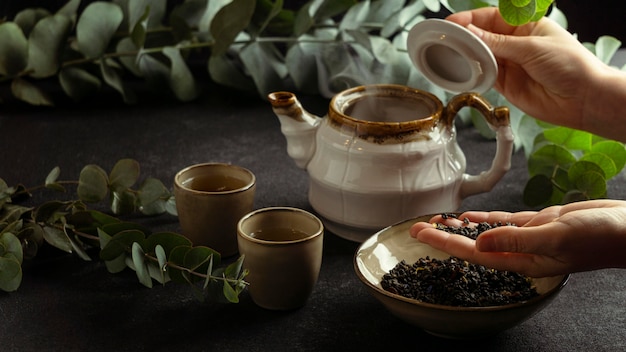 Mano de primer plano sosteniendo los ingredientes del té