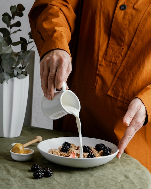 Foto gratuita mano de primer plano vertiendo leche