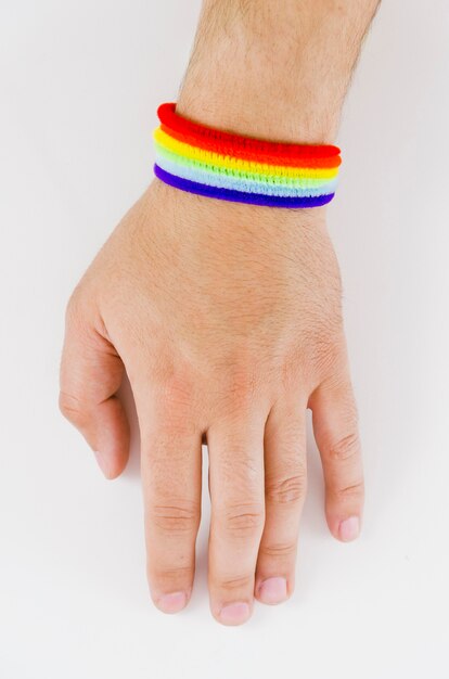 Mano con una pulsera de la bandera del orgullo