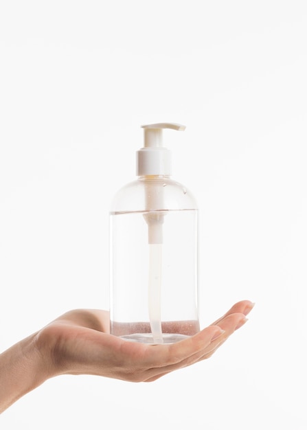 Foto gratuita mano que sostiene la botella de desinfectante de manos