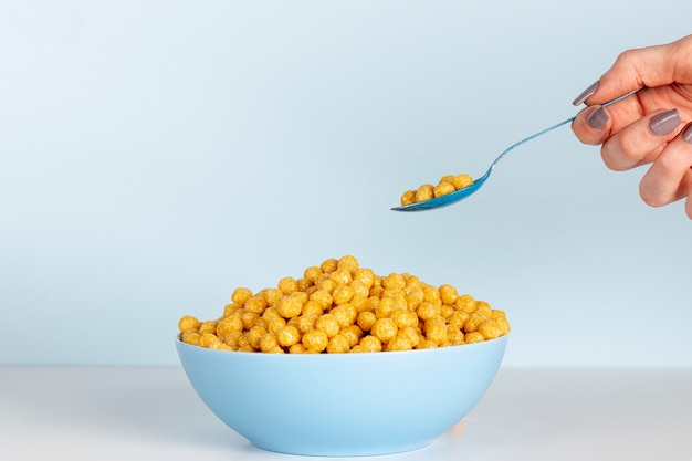 Foto gratuita mano que sostiene la cuchara llena de cereales con copia espacio de fondo