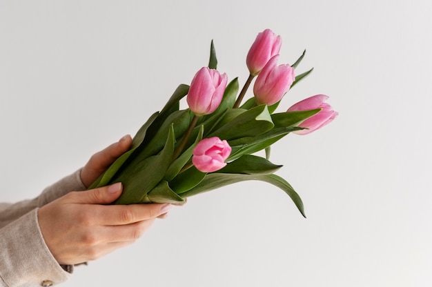 Foto gratuita mano que sostiene la flor elegante